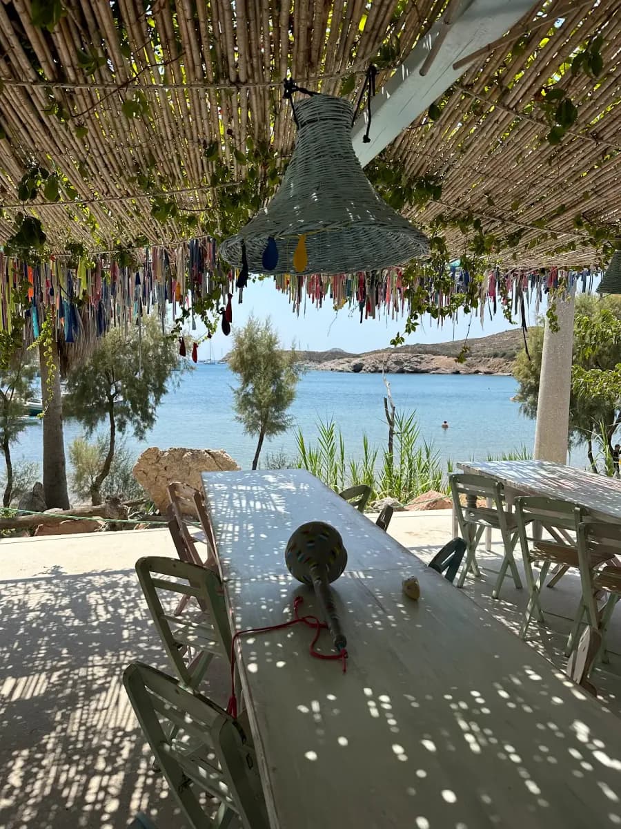 A shaded waterside terrace looking across a quiet Lipsi bay