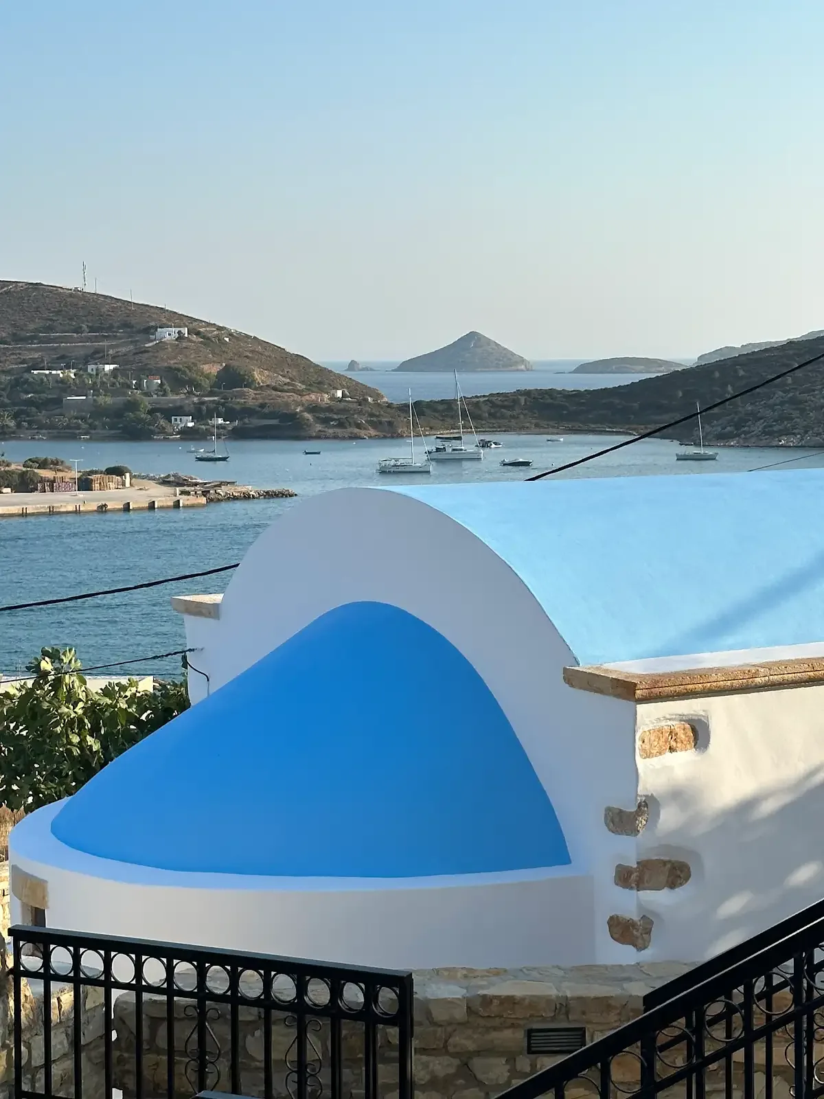 Lipsi harbour and nearby islands seen beyond a blue-and-white church dome